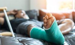 Bone fracture foot and leg on male patient with splint cast and crutches during surgery rehabilitation and orthopaedic recovery staying at home